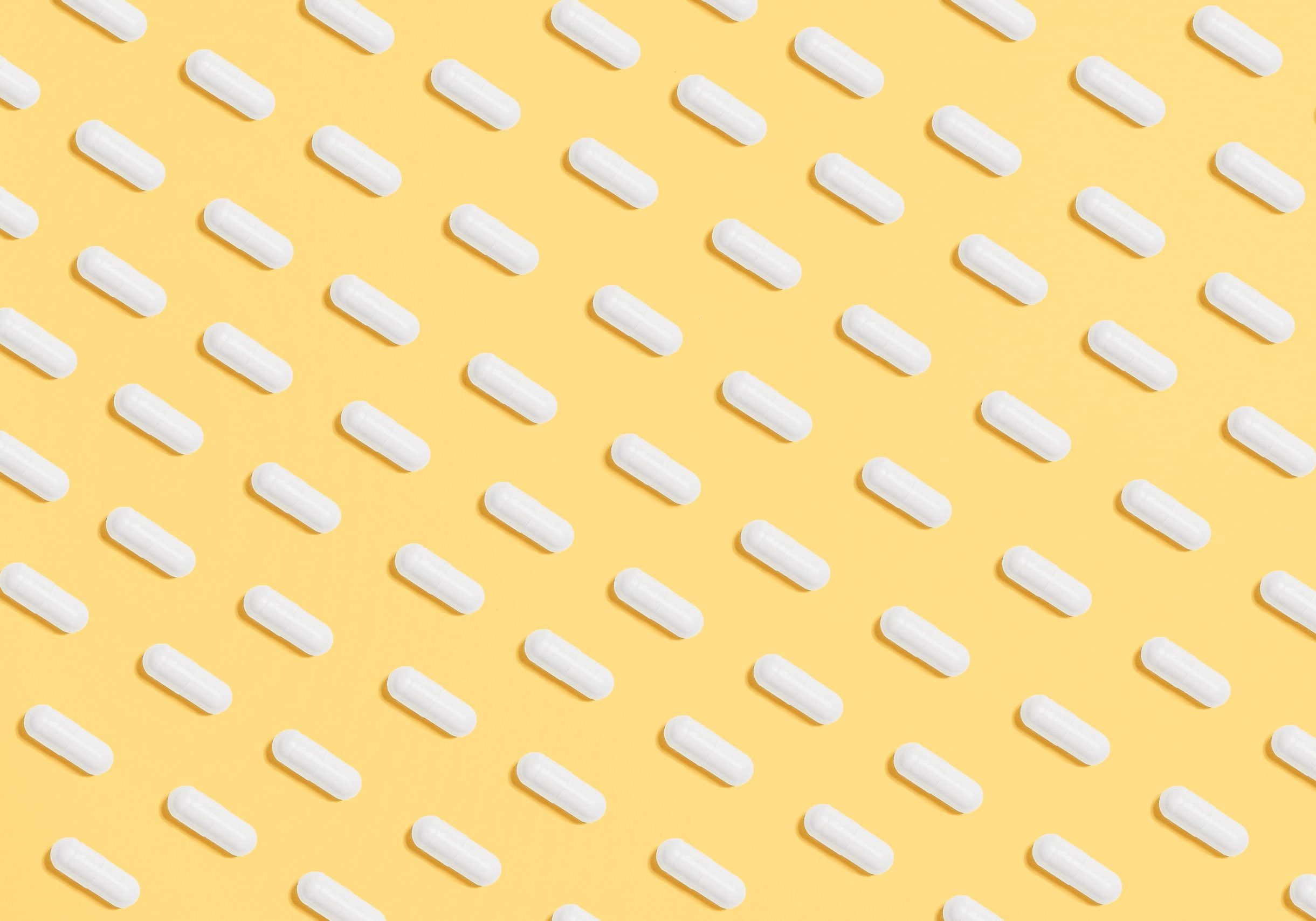white-capsules-on-yellow-background-3683056